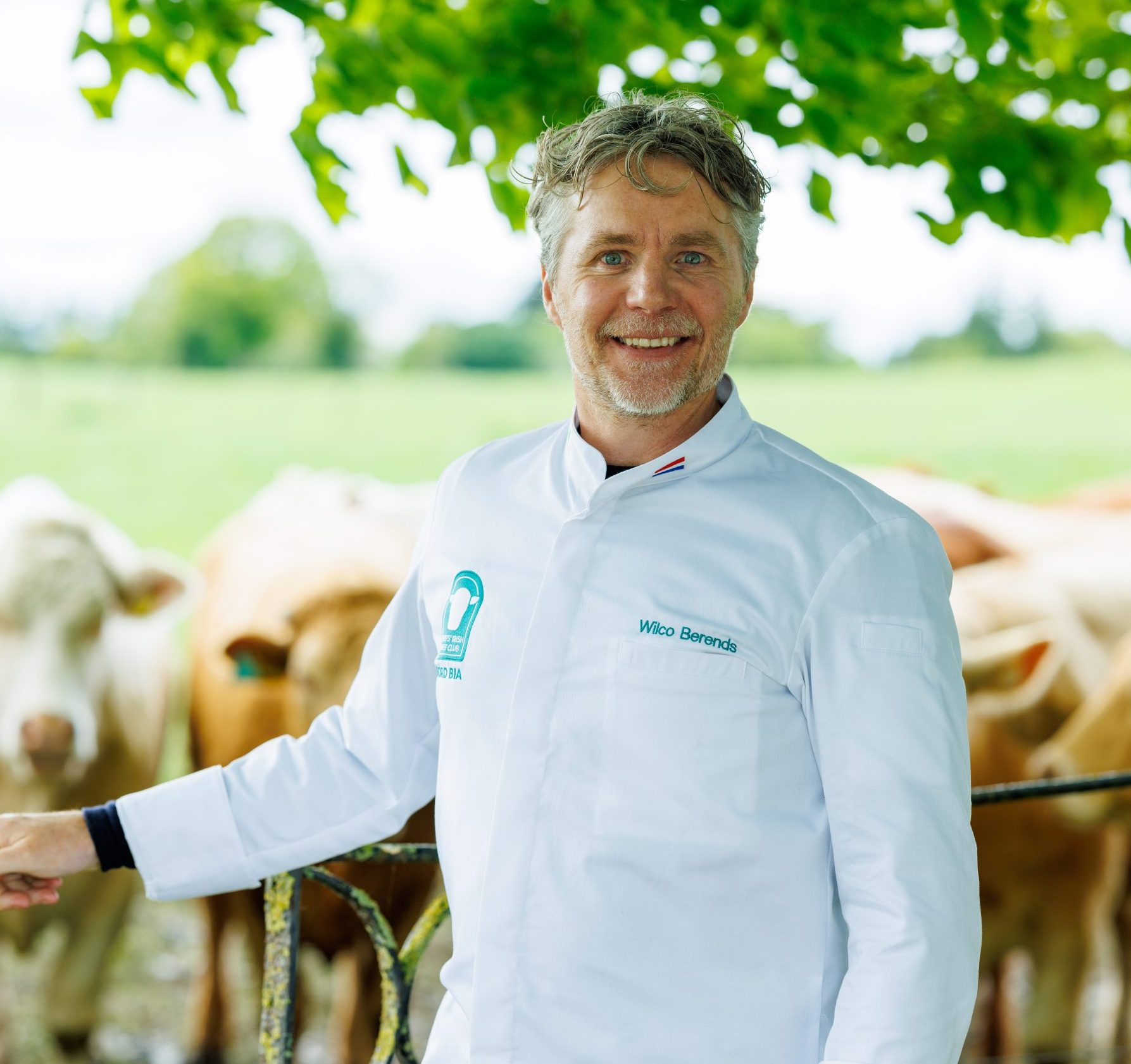 CIBC Chef Wilco Berends in CIBC jacket in front of cattle in Ireland